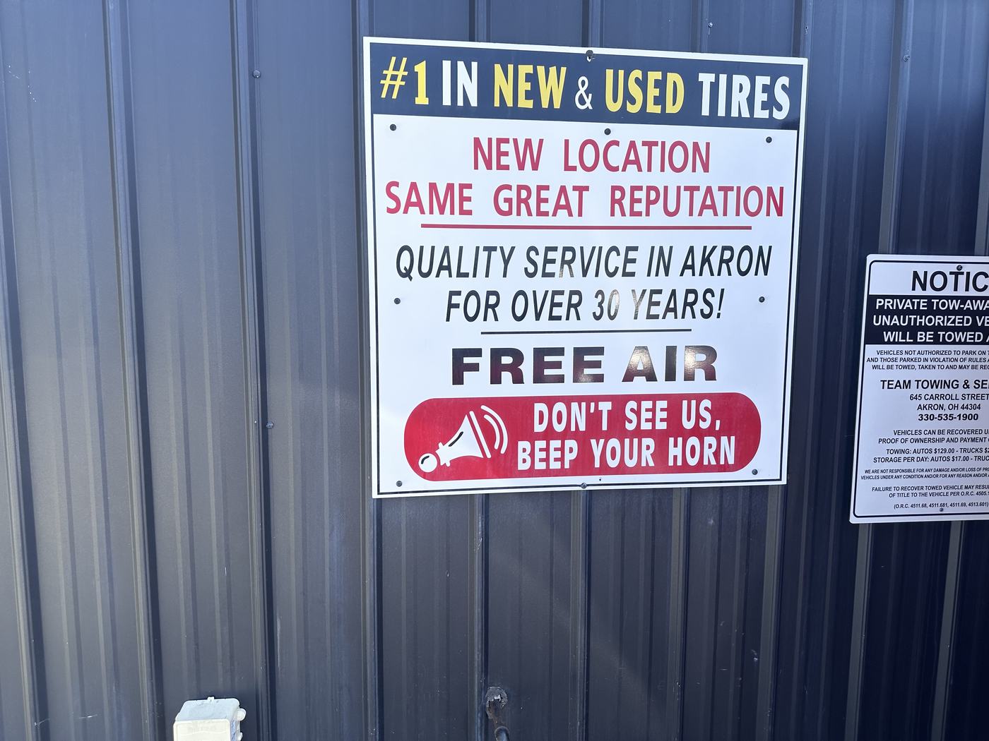 Sign at U Need A Tire reading Number 1 in new and used tires, quality service in Akron for over 30 years, free air